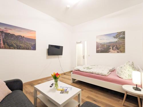 a white room with a bed and a table at UO0 - Urlaubsmagie - Gemütliche Wohnung für bis zu 6P in Sebnitz