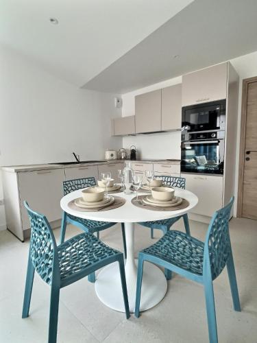 une cuisine avec une table blanche et deux chaises dans l'établissement Le Baule D'air, à La Baule