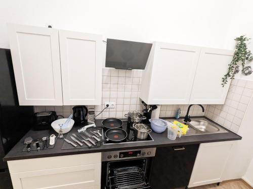 a kitchen with white cabinets and a stove top oven at UO0 - Urlaubsmagie - Gemütliche Wohnung für bis zu 6P in Sebnitz
