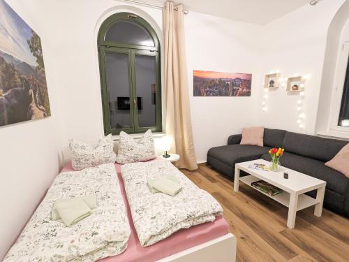 a small room with a bed and a couch at UO0 - Urlaubsmagie - Gemütliche Wohnung für bis zu 6P in Sebnitz