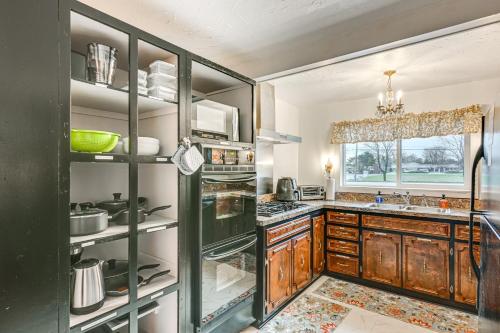 a kitchen with wooden cabinets and a refrigerator at 2 Mi to Downtown Flushing Spacious Retreat! in Flint