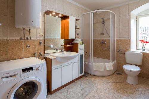 een badkamer met een wasmachine en een wastafel bij Apartment See Everlasting Split in Split