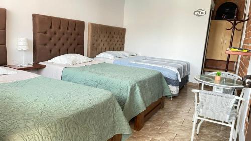 a hotel room with two beds and a glass table at Huacachina Desert House in Ica