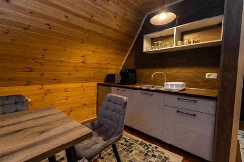 a kitchen with a table and chairs and a sink at Cabana la Piatră in Pojorîta