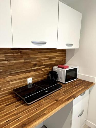 une cuisine avec un comptoir avec un micro-ondes dans l'établissement Drancy, spacieux hébergement, à Drancy