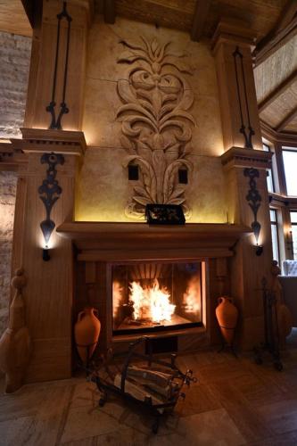 a fireplace in a living room with a fire at HOTEL EMROVIC RAJ in Novi Pazar