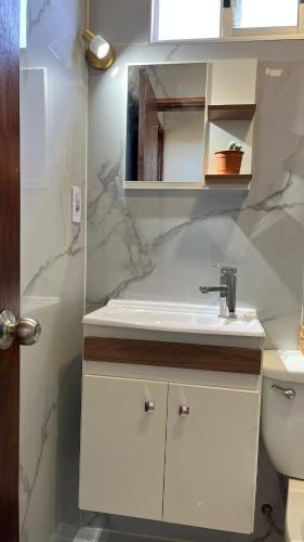 a white bathroom with a sink and a toilet at Las Marinas Playa Grande 1 in Piriápolis