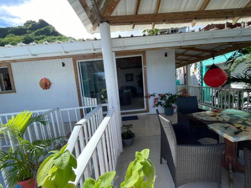 a porch of a house with a table and chairs at Cabaña sunrise view in Providencia