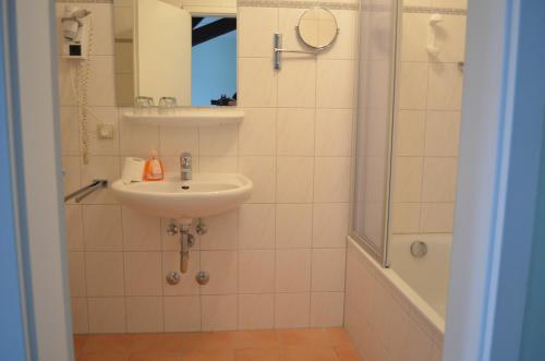 a bathroom with a sink and a shower at Alte Post - Hotel Am Rhein-Ufer Laufenburg in Laufenburg