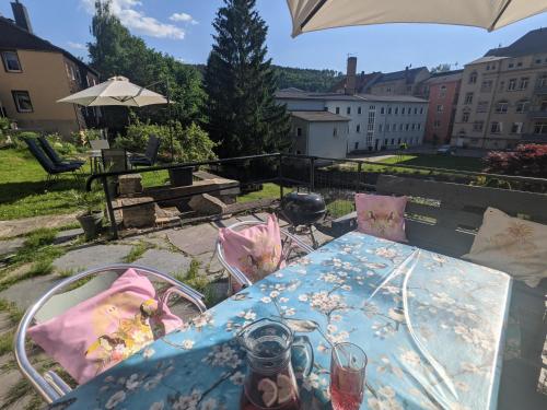 a table on a balcony with an umbrella at UO0 - Urlaubsmagie - Gemütliche Wohnung für bis zu 6P in Sebnitz