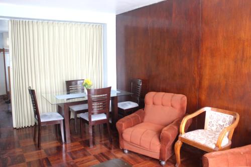 a living room with a chair and a table at Alquilo Dpto Equipado San Isidro in Lima