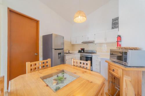 a kitchen with a wooden table and a refrigerator at GoBaja Villas 2 bedroom in La Paz