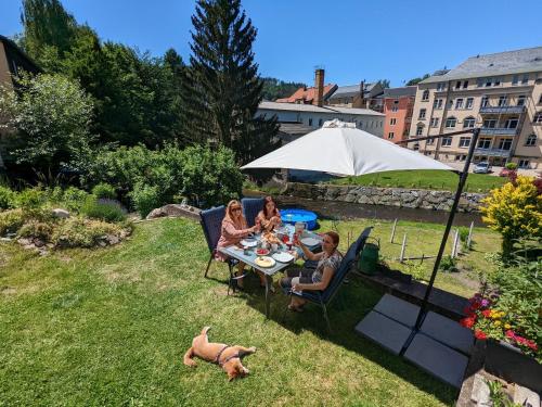 a group of people sitting at a table in a garden at UO0 - Urlaubsmagie - Gemütliche Wohnung für bis zu 6P in Sebnitz