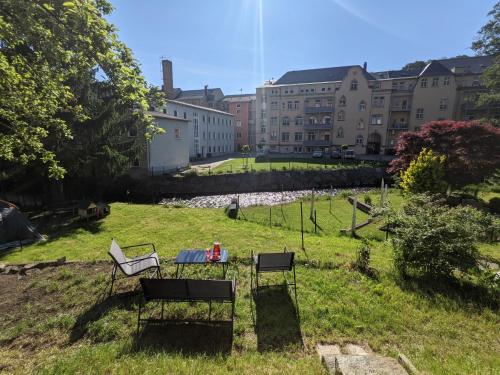 a park with two chairs and a table in the grass at UO0 - Urlaubsmagie - Gemütliche Wohnung für bis zu 6P in Sebnitz