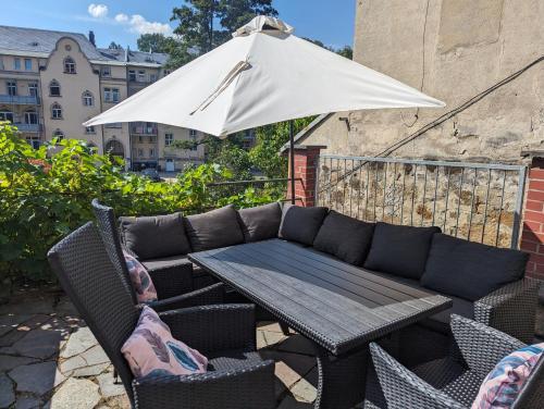 a patio with a table and an umbrella at UO0 - Urlaubsmagie - Gemütliche Wohnung für bis zu 6P in Sebnitz