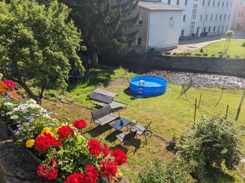 an aerial view of a garden with flowers and a blue tub at UO0 - Urlaubsmagie - Gemütliche Wohnung für bis zu 6P in Sebnitz