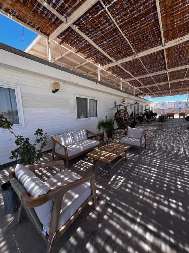 a screened in porch with couches and a table and chairs at Hospedaje la Florentina in Pica