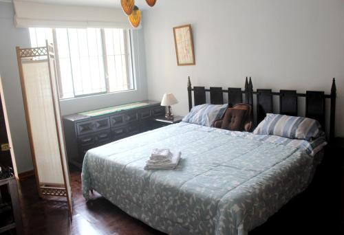 a bedroom with a large bed with a blue comforter at Alquilo Dpto Equipado San Isidro in Lima
