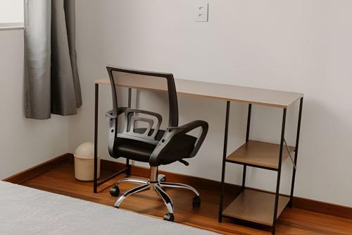 a desk with a black chair and a glass desk at Mini Loft Siena in Sinop