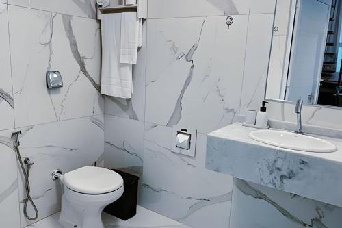 a white bathroom with a toilet and a sink at Mini Loft Siena in Sinop