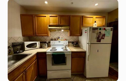 a kitchen with a stove and a white refrigerator at Camila In in Philadelphia