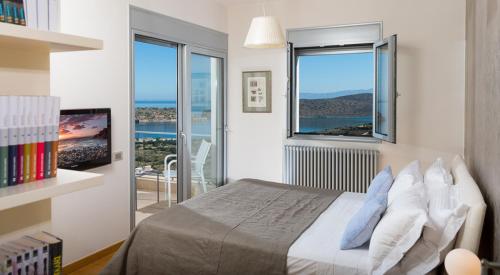 a bedroom with a bed with a view of the ocean at Elounda Luxury Villas in Elounda
