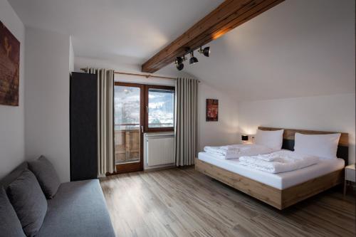 a bedroom with a bed and a large window at Alpine View Apartments in Niedernsill
