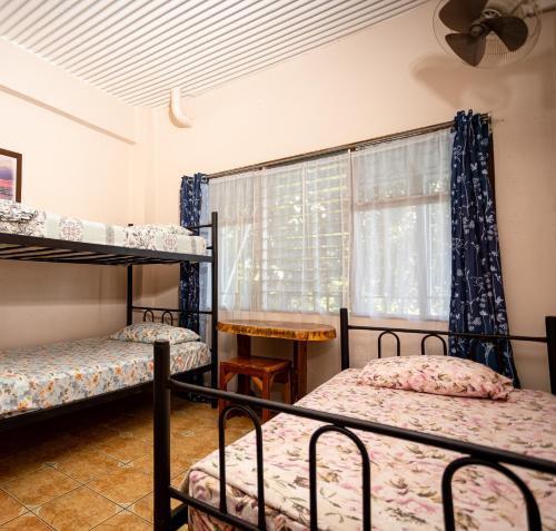 Una cama o camas en una habitación de Manuel Antonio Hostel