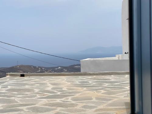 a view from a window of a patio with mountains in the background at Cyclops House in Serifos Chora