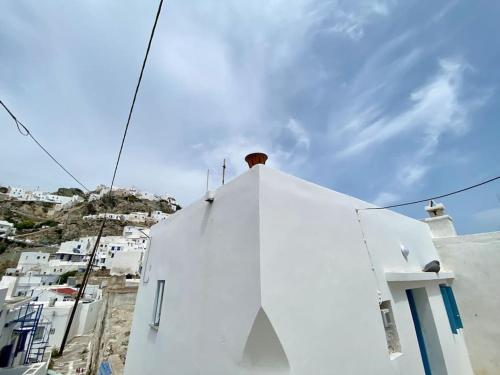 a white building with a chimney on top of it at Cyclops House in Serifos Chora