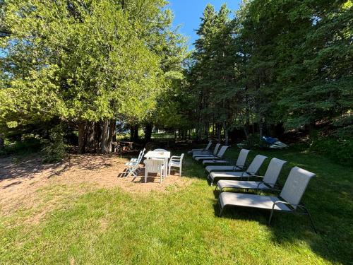 a row of benches with tables and chairs in the grass at Island Estate in La Pointe