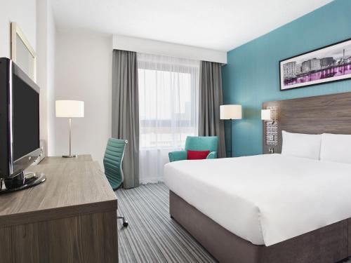 a hotel room with a large bed and a tv at Leonardo Hotel Southampton in Southampton