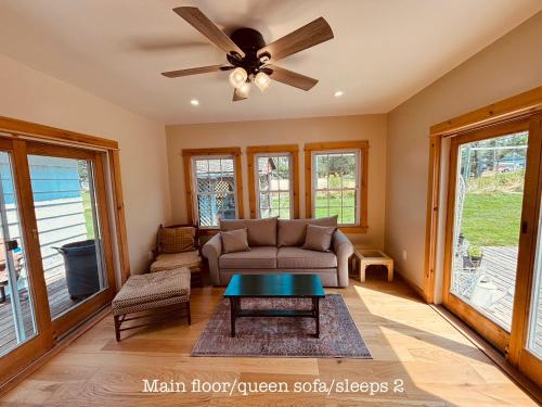 a living room with a couch and a ceiling fan at Island Estate in La Pointe