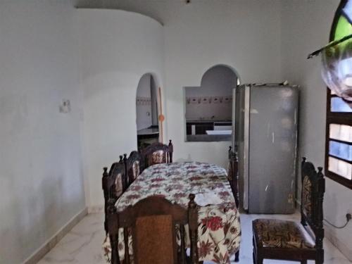 a kitchen with a refrigerator and a table and chairs at Precious Bungalow House in Lamu