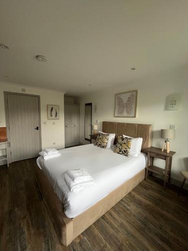 a bedroom with a large bed with white sheets and pillows at Pine, Country chalet located in Pegsdon in Hexton