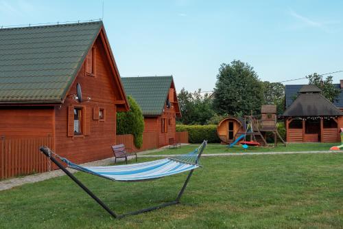 a hammock in a yard next to a house at Domki Krótki Szpic in Istebna