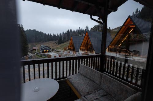 a room with a couch on a balcony with a view at Cabana la Piatră in Pojorîta