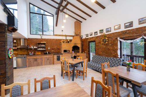 an open kitchen and dining room with tables and chairs at Cabana la Piatră in Pojorîta