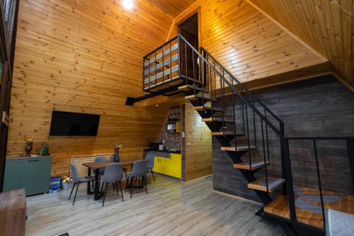 a staircase in a room with a table and chairs at Cabana la Piatră in Pojorîta
