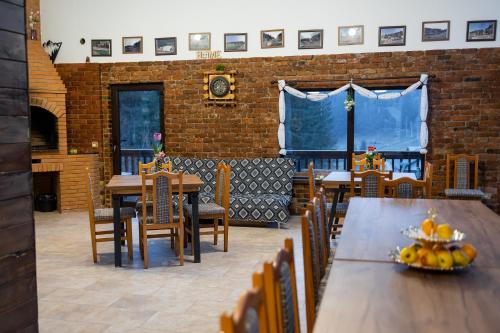 a dining room with tables and chairs and a clock at Cabana la Piatră in Pojorîta
