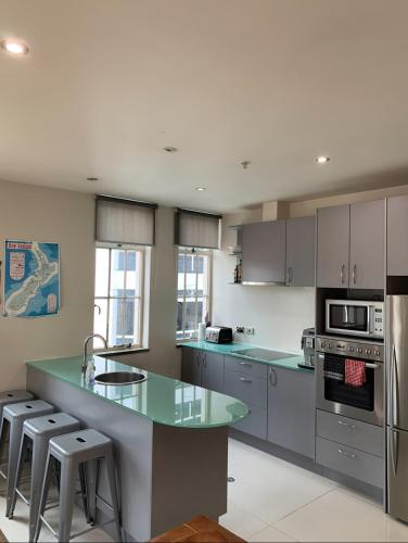a kitchen with green countertops and stainless steel appliances at Outstanding Central Lambton Quay Apartment in Wellington