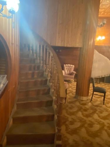 a spiral staircase in a room with a chair at Gogol House in Kutaisi