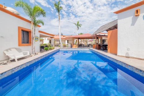 a swimming pool at a resort with palm trees at Go Baja Villas 2 Bedroom (King) in La Paz
