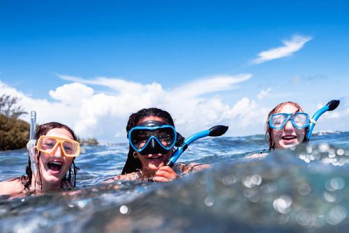three women in the water wearing diving gear at Turtle Inn by Francis Ford Coppola in Placencia Village
