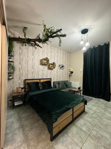 une chambre avec un grand lit avec une couverture verte dans l'établissement Le cocon, à Reims