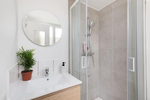 a bathroom with a shower and a sink and a mirror at Elégant Flat Paris CDG Expo in Aulnay-sous-Bois