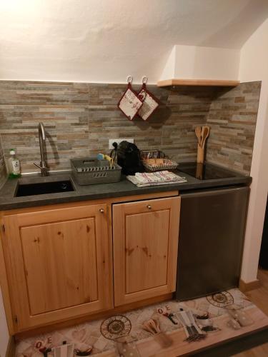 a kitchen with a sink and a dishwasher at alloggio in centro con giardino in Sampeire