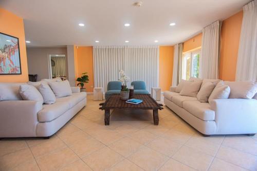 a living room with two couches and a coffee table at Arashi Beachfront - The best sunsets in Aruba! in Madiki