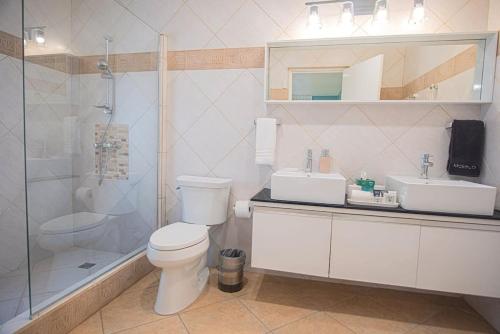 a bathroom with a toilet and a sink and a shower at Arashi Beachfront - The best sunsets in Aruba! in Madiki