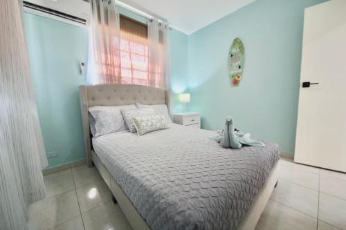 a bedroom with a bed in a room with blue walls at Beija Flor Entire home in Oranjestad, Aruba in Paradijs